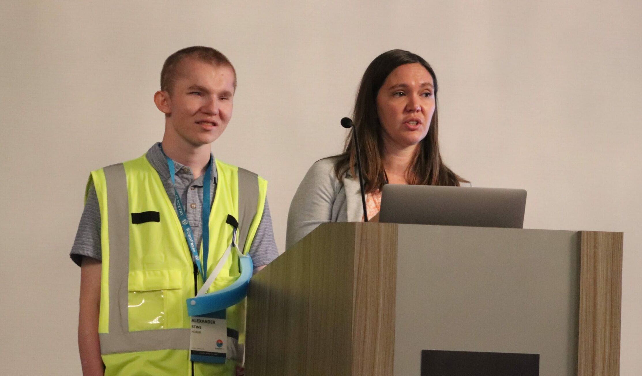 Alex Stine and Amber Hinds speak at the podium during WordCamp US 2022.